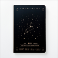 Front view of a matte black hardcover Leo zodiac journal featuring a gold star map constellation design centered on a clean white background.