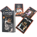 Dancing in the Dark Tarot cards fanned out around a black tuck box showing a woman reaching toward a glowing crescent moon.