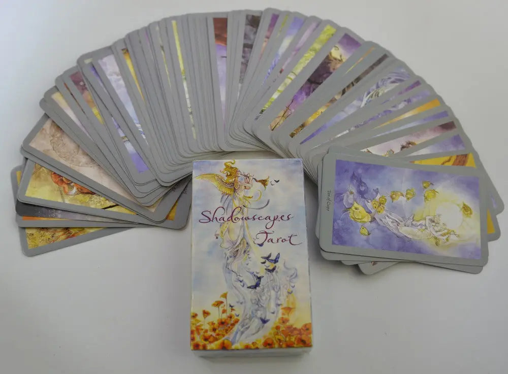 Shadowscapes Tarot cards fanned out wide next to their illustrated front cover box displaying a white phoenix.