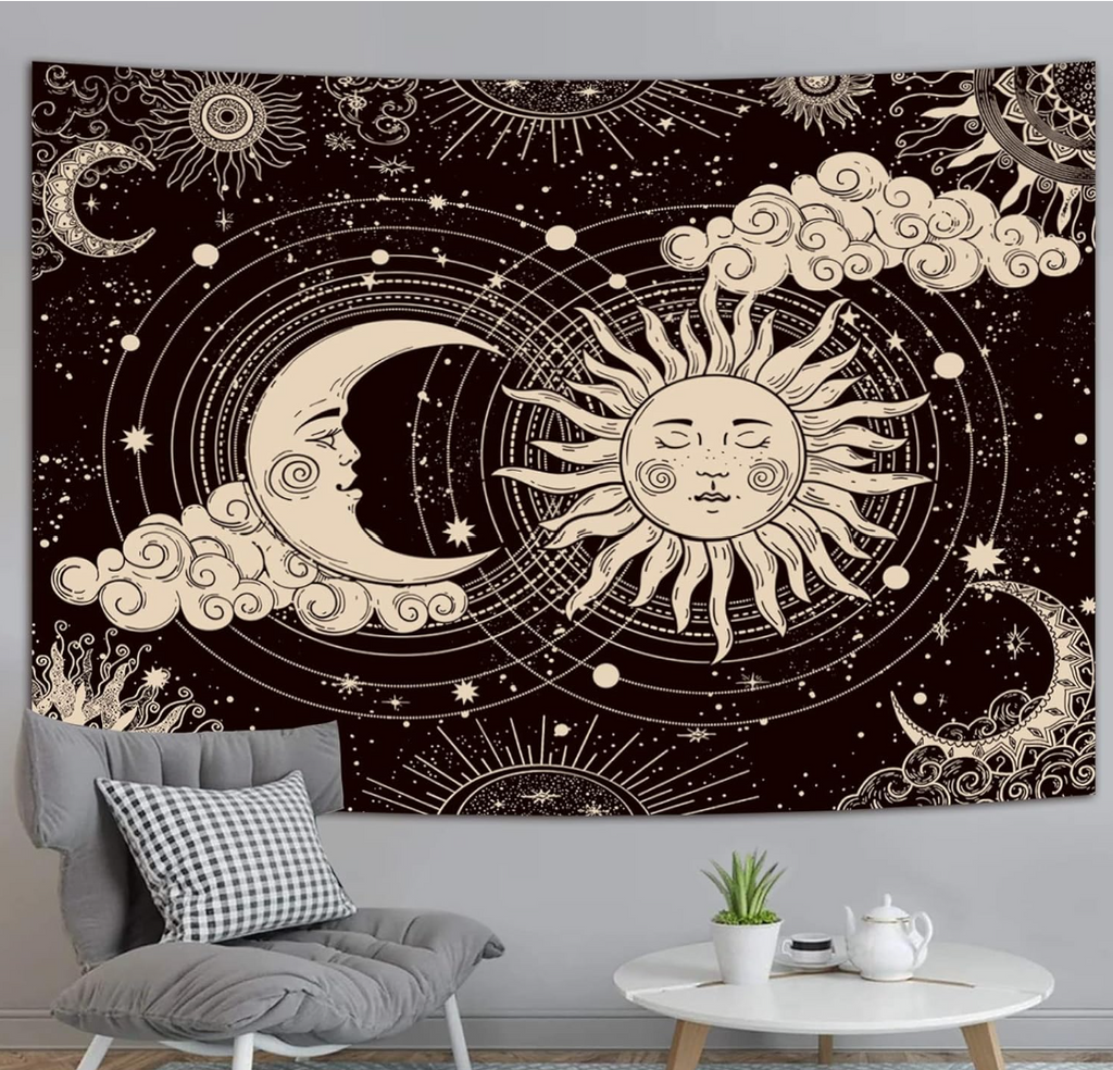 Mystic sun and a crescent moon tapestry with faces, surrounded by stars, clouds, and hanging on a wall behind a small table and chair