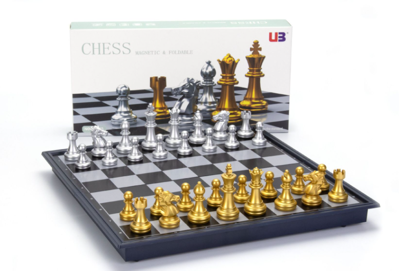 White retail box standing behind a fully set up gold and silver magnetic chess set.