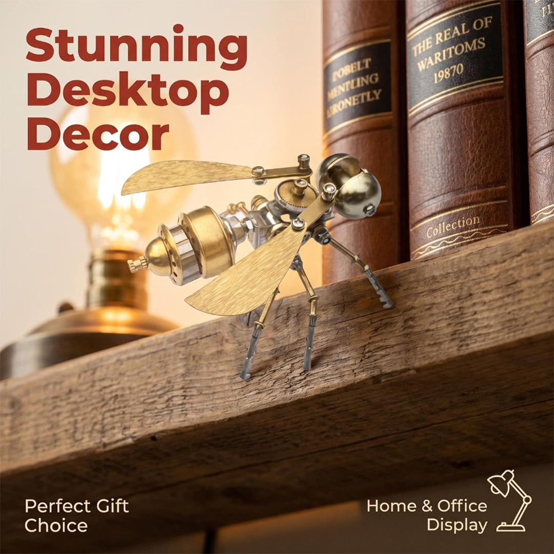 A finished brass-and-silver mechanical bug model standing on a rustic wooden shelf next to old leather-bound books under warm ambient light. Large text reading "Stunning Desktop Decor" sits at the top left, with "Perfect Gift Choice" and "Home & Office Display" noted at the bottom.