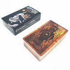 The black illustrated tuck box standing vertically next to an orange and black card backing showing symmetrical stars.