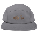 Grey five-panel camper style hat featuring the elegant Anakha H Nyx calligraphy script logo embroidered in a warm copper bronze tone across the front.