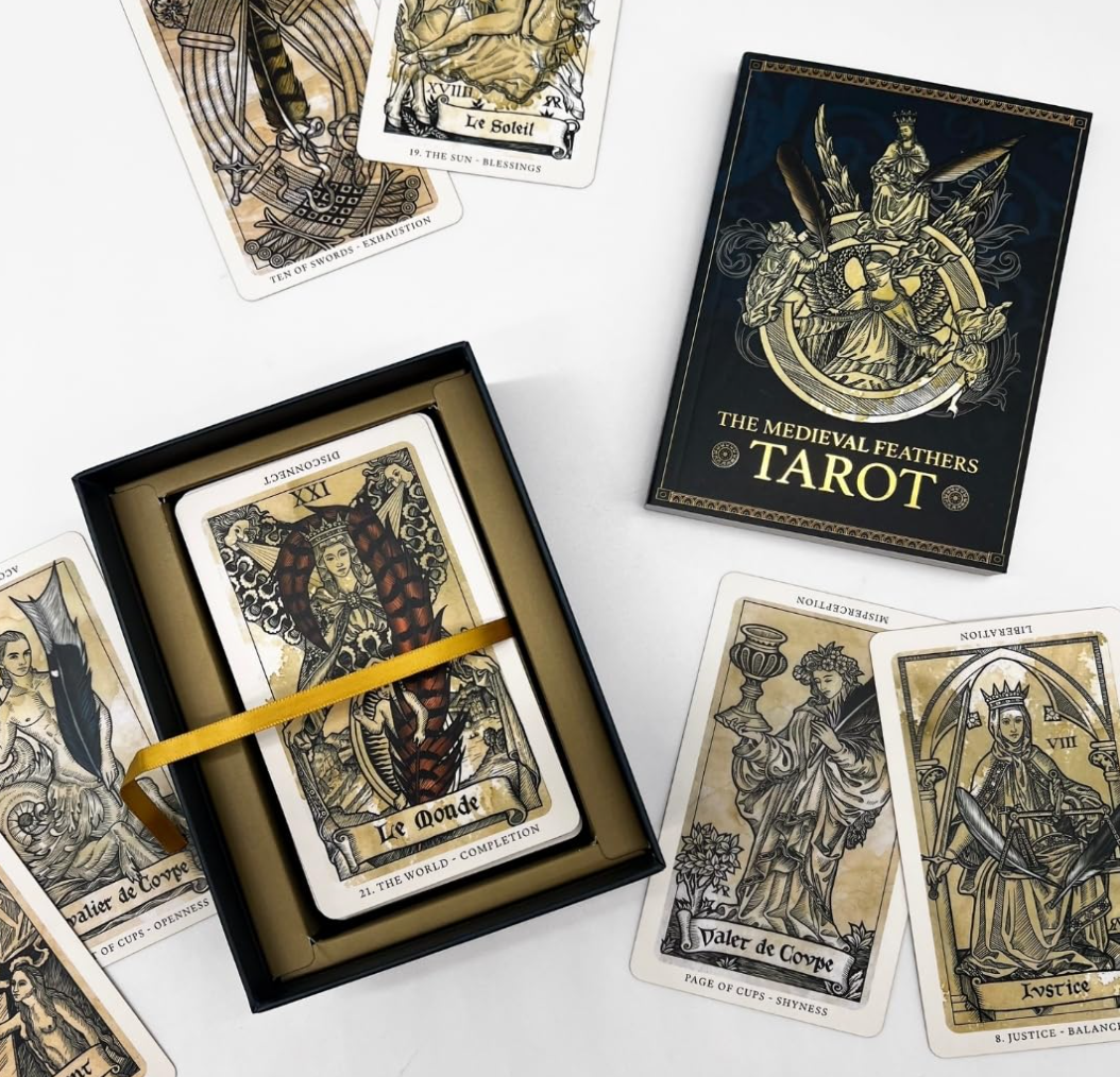 The Medieval Feathers Tarot display box with ribbon and guidebook