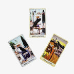 Three gothic Crow Tarot cards fanned out on a white surface for a symbolic past, present, and future layout.