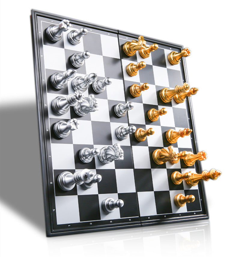 Silver and gold magnetic chess pieces staying firmly attached to a black and white chess board held vertically