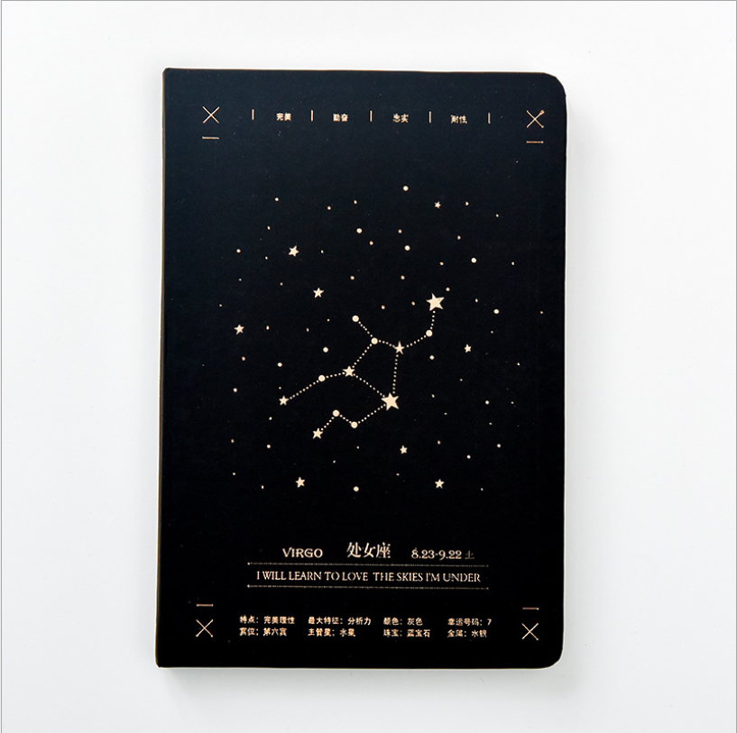 Front view of a matte black hardcover Virgo zodiac journal featuring a gold star map constellation design centered on a clean white background.