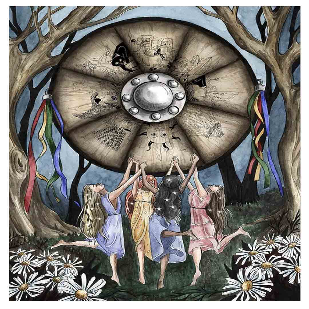 An full-page watercolor and ink artistic illustration from a book depicting a seasonal pagan ritual. In a dark, twilight forest setting flanked by large barren trees, four women with long hair dance in an active circle with their arms raised toward a massive wooden wheel floating above them. The women wear flowing dresses in light blue, golden yellow, purple, and pale pink, and white daisies are scattered across the grassy ground in the foreground. Hanging from the trees on both sides of the floating wheel 