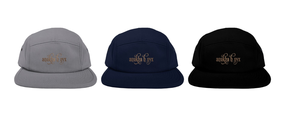 A product catalog presentation features three five-panel caps in slate gray, midnight navy blue, and matte black, each showcasing a centered bronze calligraphic embroidery line over a clean white canvas background