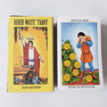 The yellow Spanish-English edition box next to the Seven of Pentacles tarot card displaying a man leaning on a shovel.