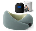 Travel memory foam neck pillow from the Dark Utility Collection in muted sage green with a light olive interior lining, modal-blend knit cover, asymmetrical ergonomic wrap profile, hook-and-loop closure, and black compression storage bag with branded travel canister. 