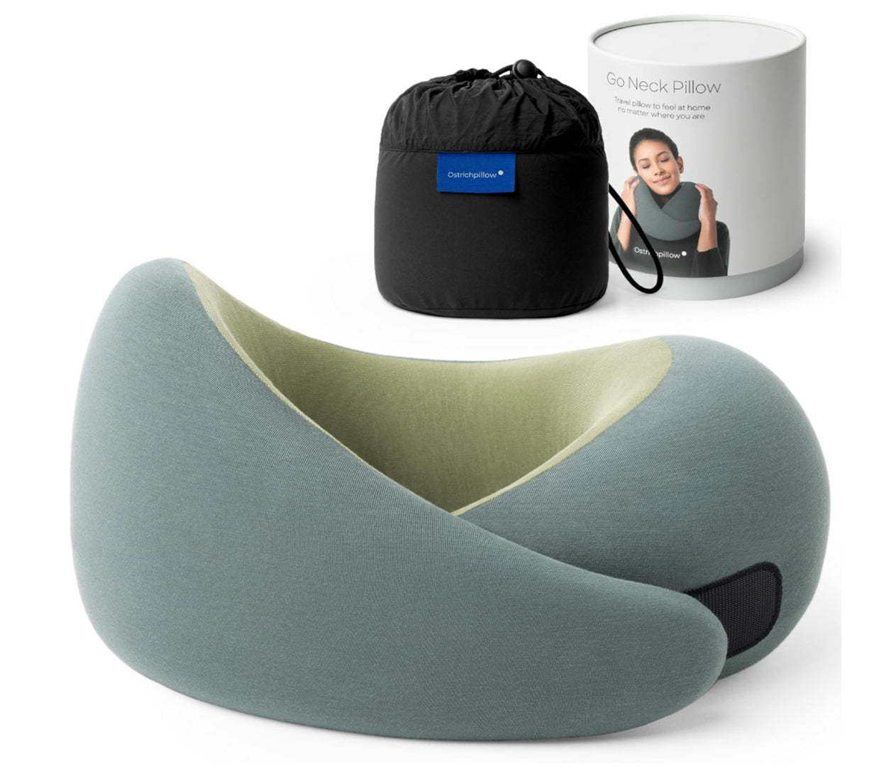 Travel memory foam neck pillow from the Dark Utility Collection in muted sage green with a light olive interior lining, modal-blend knit cover, asymmetrical ergonomic wrap profile, hook-and-loop closure, and black compression storage bag with branded travel canister. 