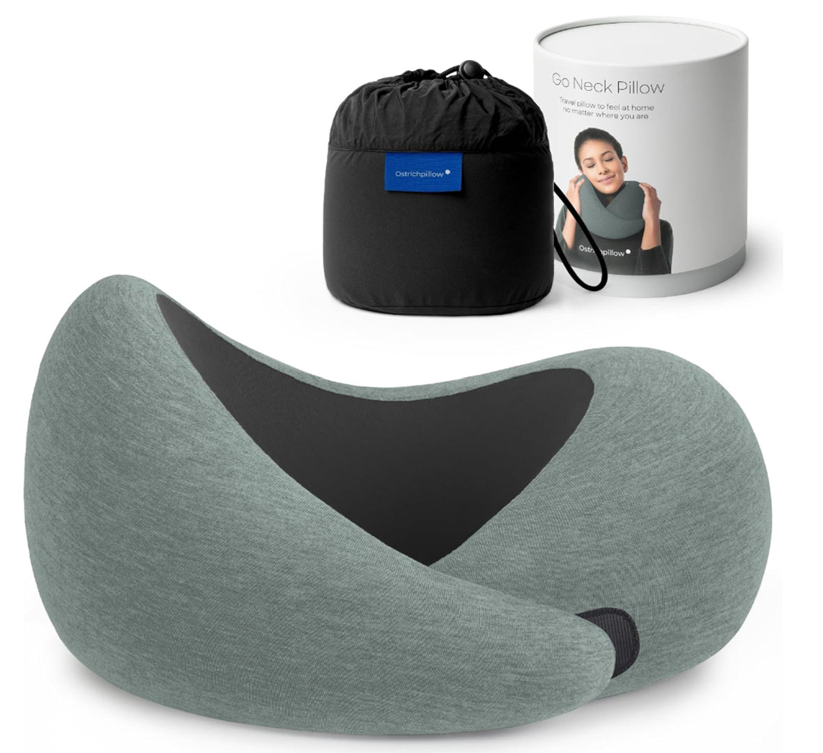 Go Neck travel pillow from the corporate goth and dark luxury streetwear accessory collection featuring a moss green heather knit fabric exterior, black stretch fabric inner support panel, ergonomic wraparound memory foam construction with overlapping front closure, concealed hook-and-loop fastening, woven brand label, and black drawstring travel pouch. Product image displays the neck pillow with cylindrical retail packaging, emphasizing minimalist gothic travel gear, premium comfort accessory design.