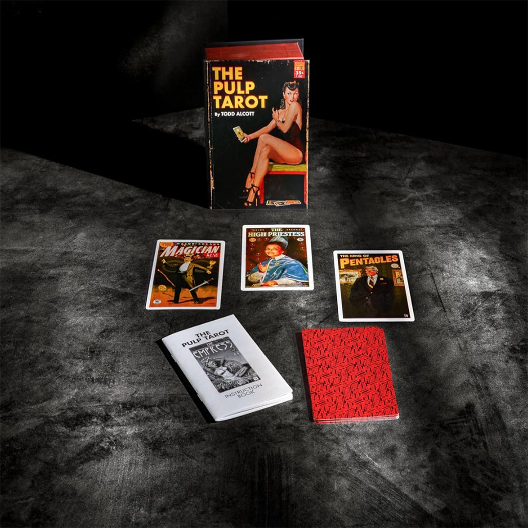The Pulp Tarot lifestyle flatlay highlights Todd Alcott's 78-card divination deck styled by the Unemployed Philosophers Guild over a textured slate background. This premium collectible presentation spreads out the vintage book-style magnetic box, the standalone instruction book, a patterned card-back stack, and illustrated archetype cards including The Magician, The High Priestess, and The King of Pentacles.