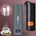 A product layout of the QRAGJBM space grey portable electric travel kettle showing its digital LED temperature display set to 212 degrees Fahrenheit next to a black leather storage bag. The image features the detachable white power plug accessories on the top left and a steaming cup of fresh coffee at the bottom left.