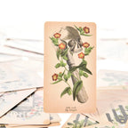 Suit of Rods Knight tarot card featuring a medical sketch of a human skull and bone profile wrapped in orange flowers.