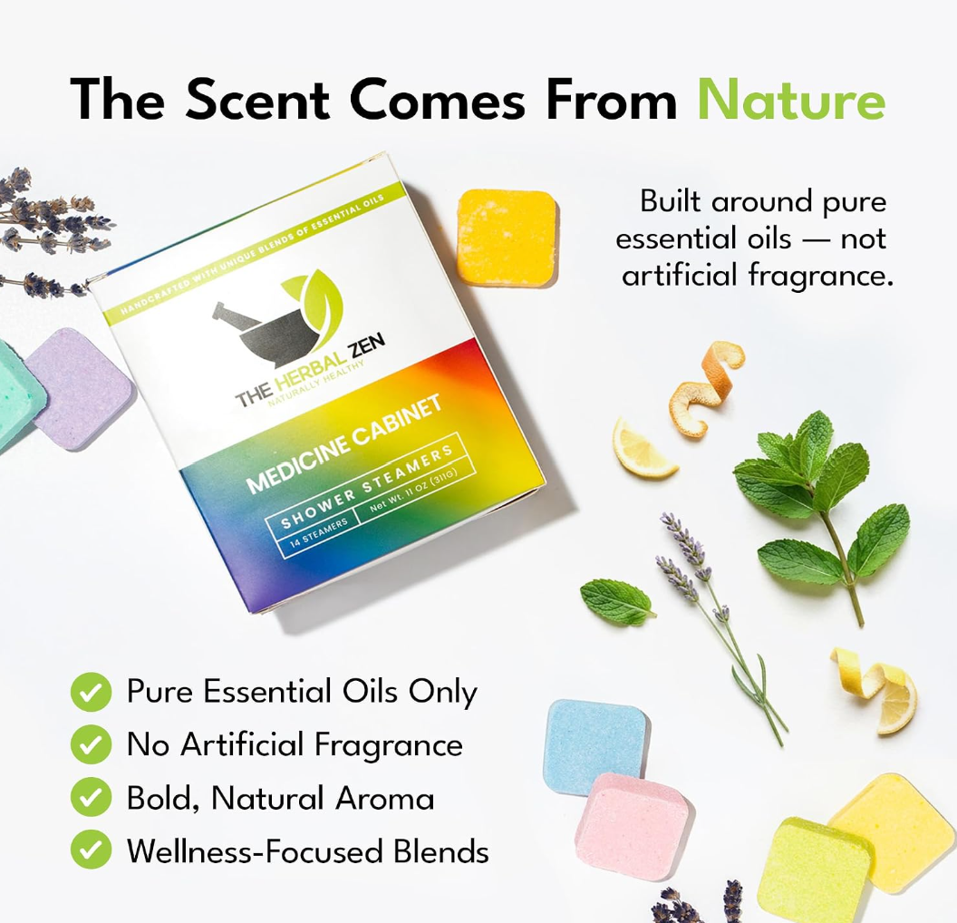 Flat lay composition showing a box of The Herbal Zen Medicine Cabinet shower steamers angled amongst scattered, colorful square tablets, fresh mint leaves, lavender sprigs, and curled lemon peels over a clean white background.