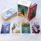 The complete White Numen Tarot kit including the cards, outer storage box, and a red hardcover instructional guidebook.