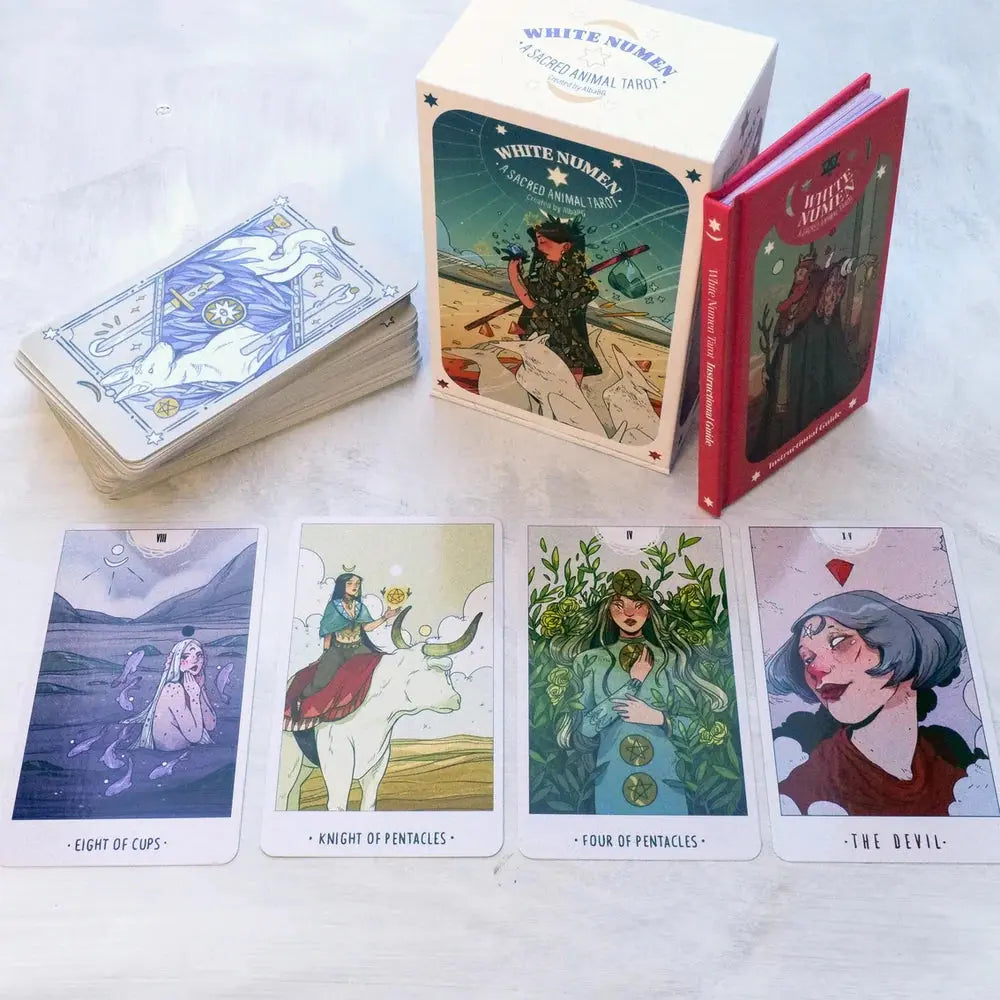 The complete White Numen Tarot kit including the cards, outer storage box, and a red hardcover instructional guidebook.